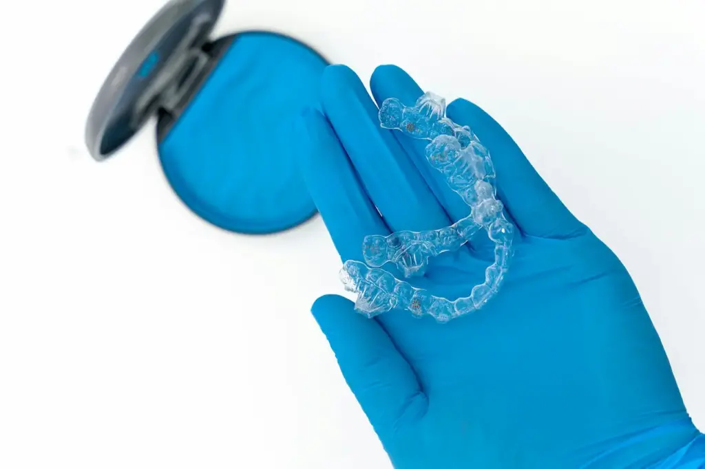 Hand with Blue Gloves Holding a Invisalign 